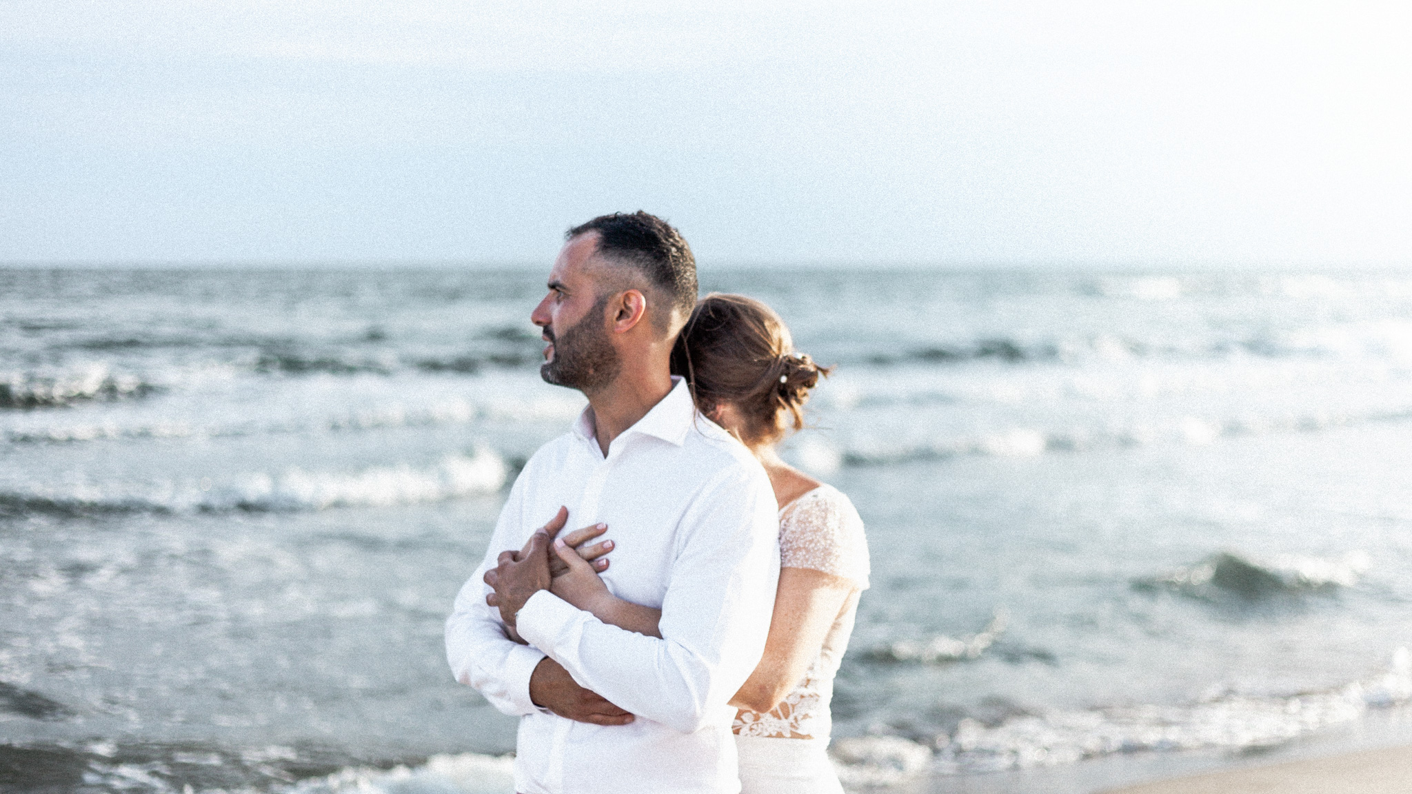 mariés enlacés sur une plage lors d'un mariage intimiste