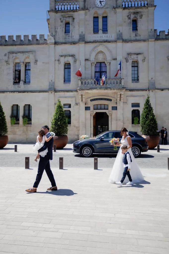 Mariée traversant le parvis de la mairie accompagnée de ses proches