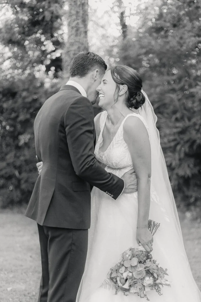 Couple de mariés enlacé dans le jardin photographié en noir et blanc