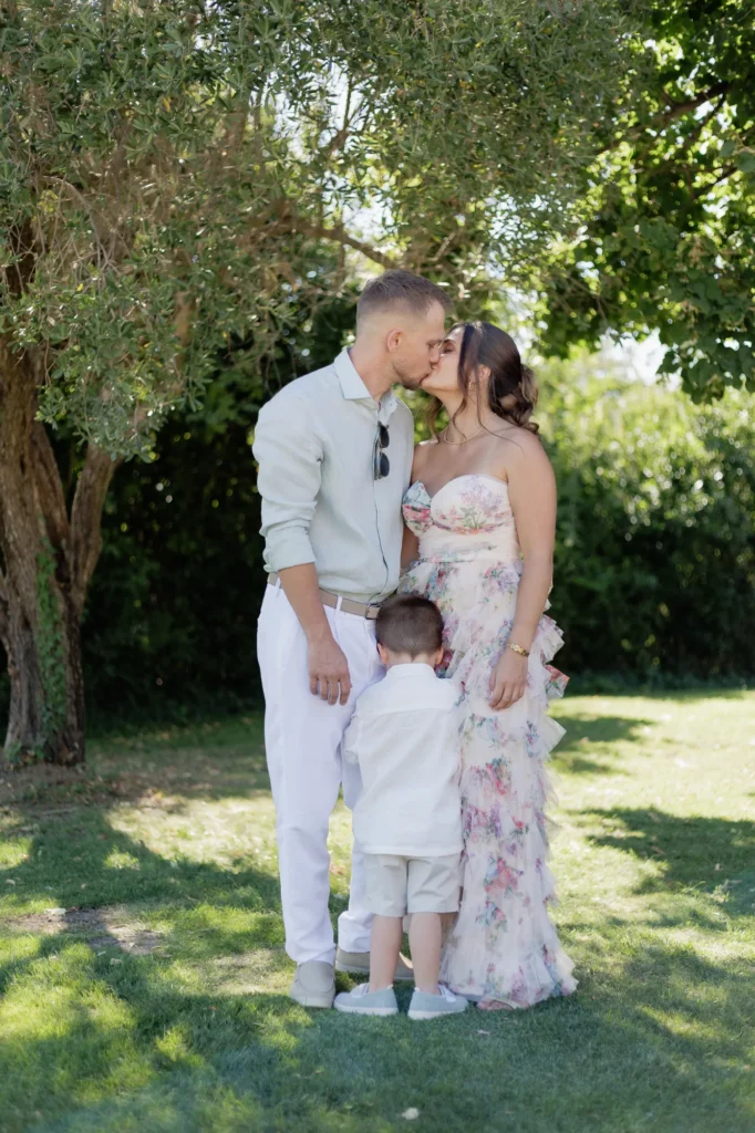 Famille partageant un moment avec un enfant dans le jardin pendant le mariage