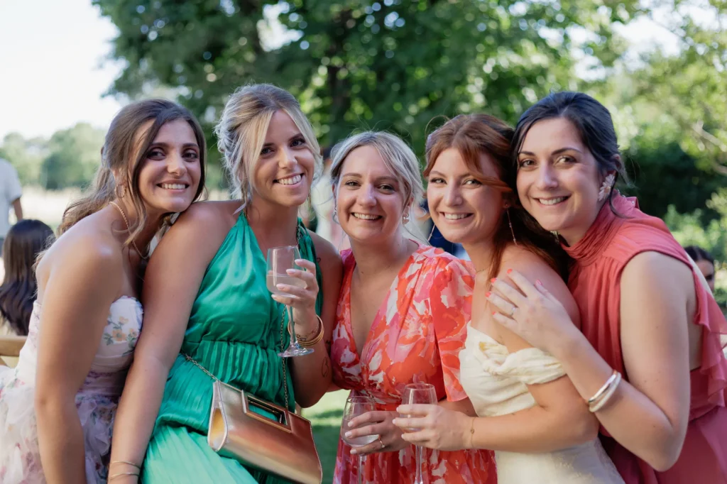 Groupe d’invitées souriant ensemble pendant le cocktail de mariage