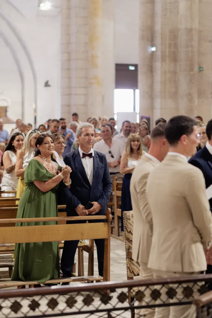 Invités debout dans l’abbatiale pendant la cérémonie religieuse des mariés