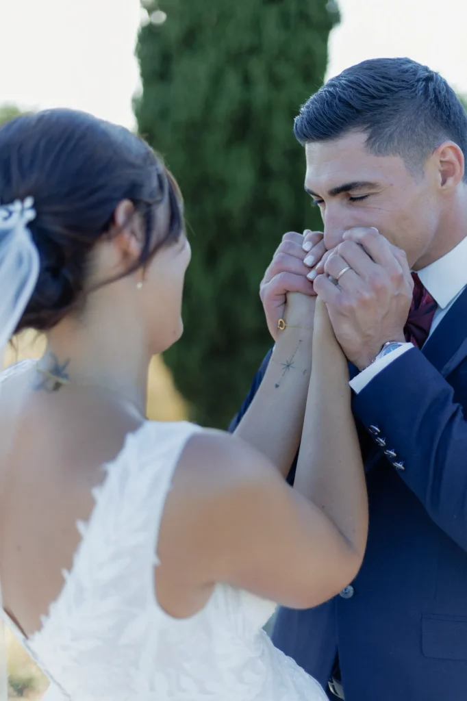 Marié embrassant la main de la mariée pendant leur séance couple