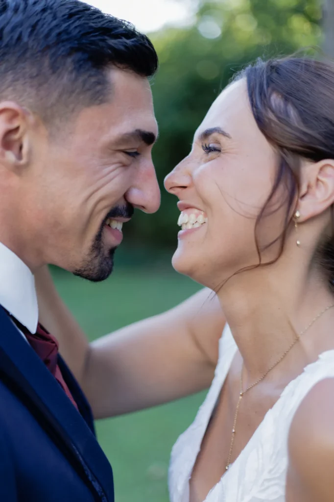 Couple de mariés souriant l’un face à l’autre pendant leur séance