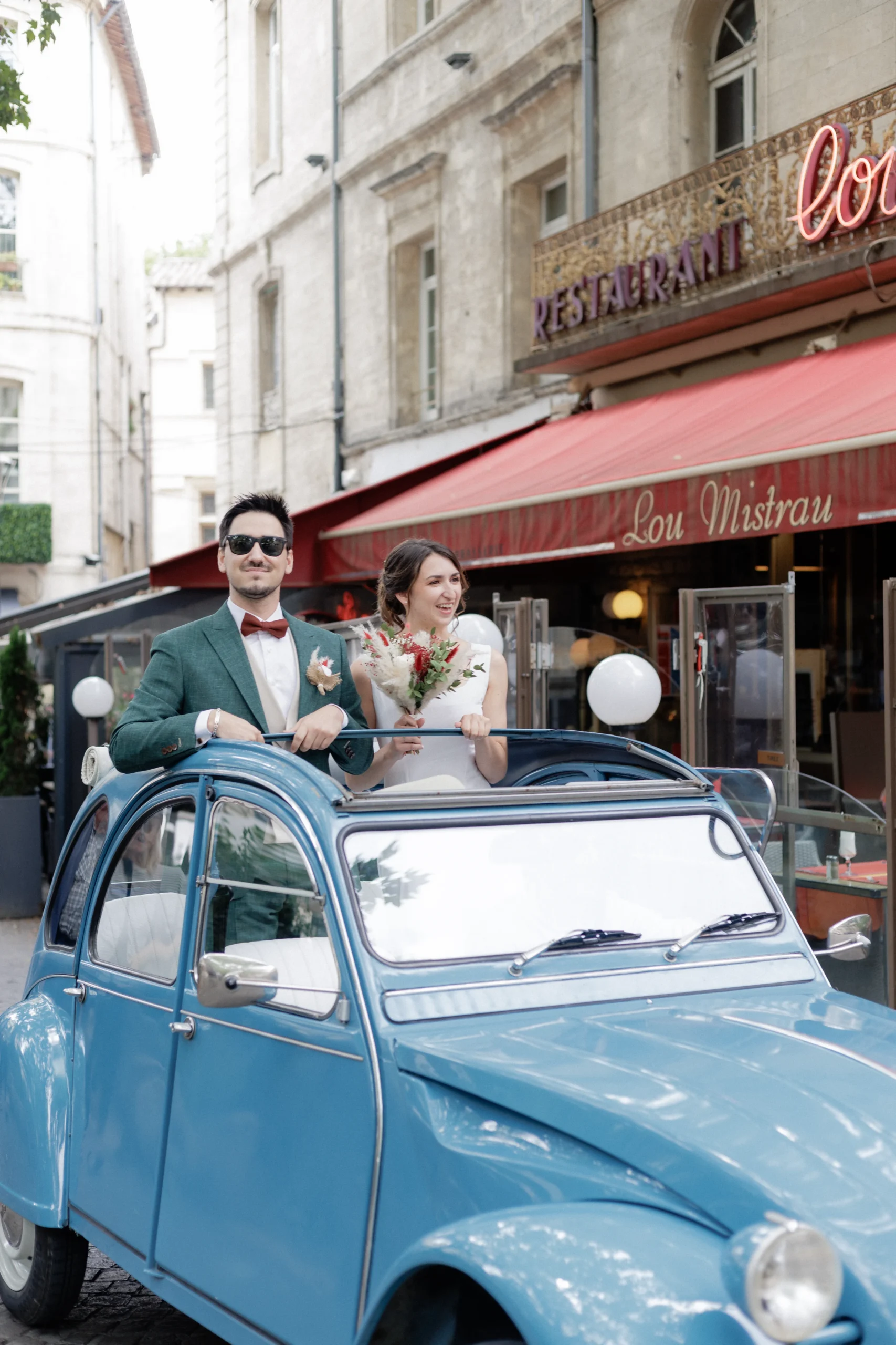 Couple de mariés dans une 2CV bleue lors de leur mariage en Provence