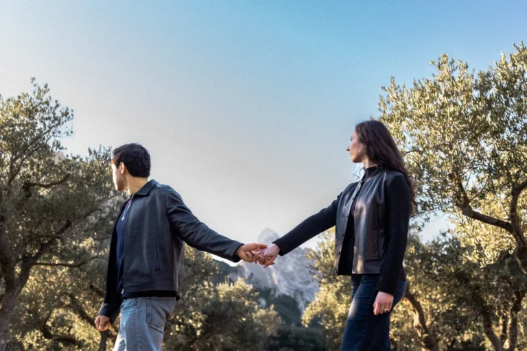 Couple se tenant par la main au milieu des oliviers lors d’une séance photo dans les Alpilles