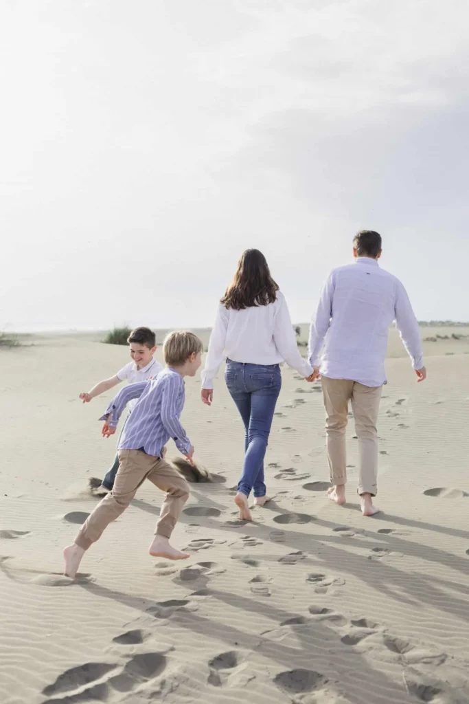 Parents marchant sur le sable avec leurs enfants pendant une séance photo en Camargue
