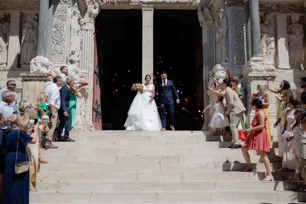 Mariés apparaissant sur les marches de l’abbatiale de Saint-Gilles après leur cérémonie