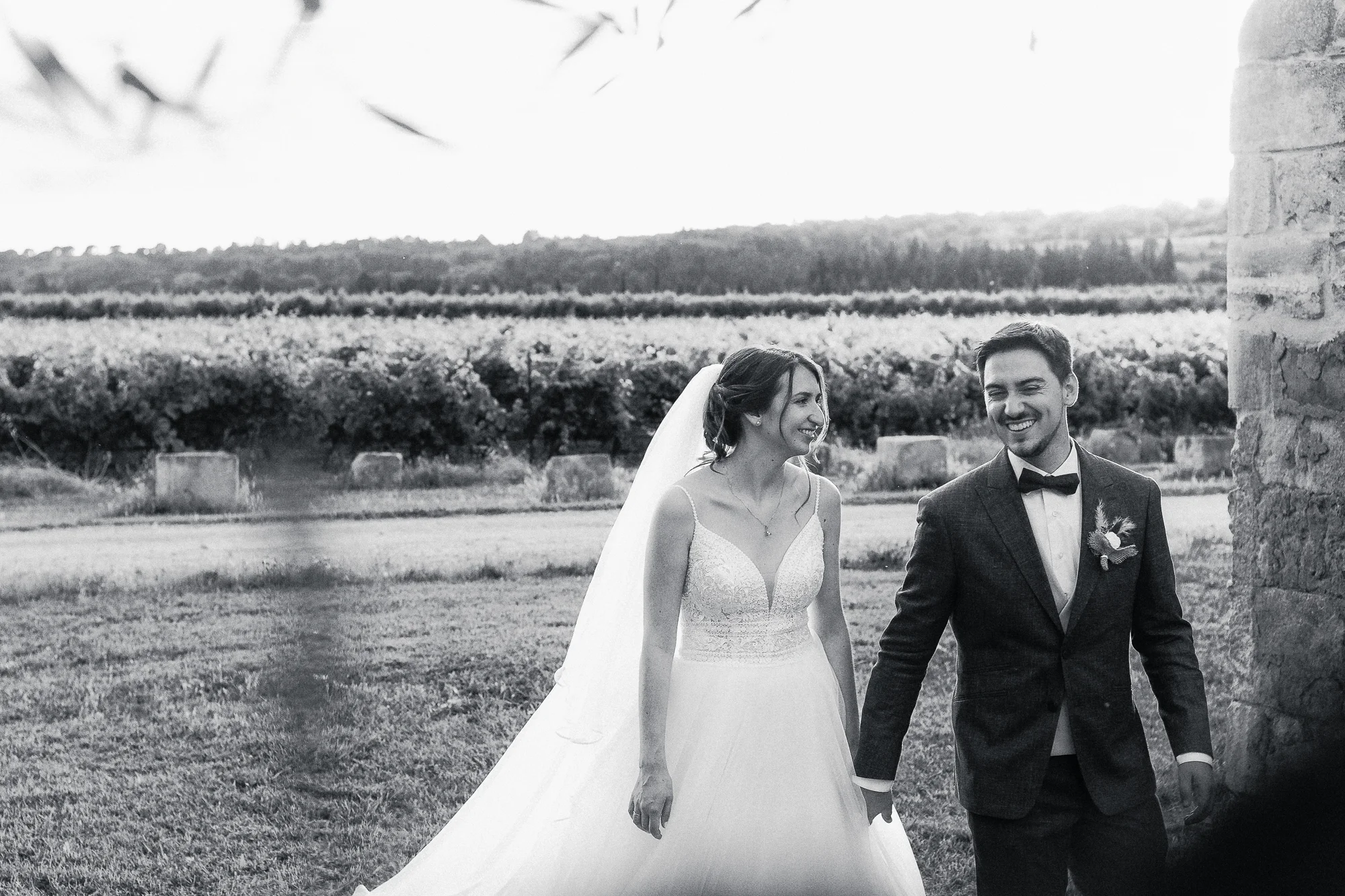 Mathilde et Romain marchent ensemble pendant leur séance couple, photographiés en noir et blanc