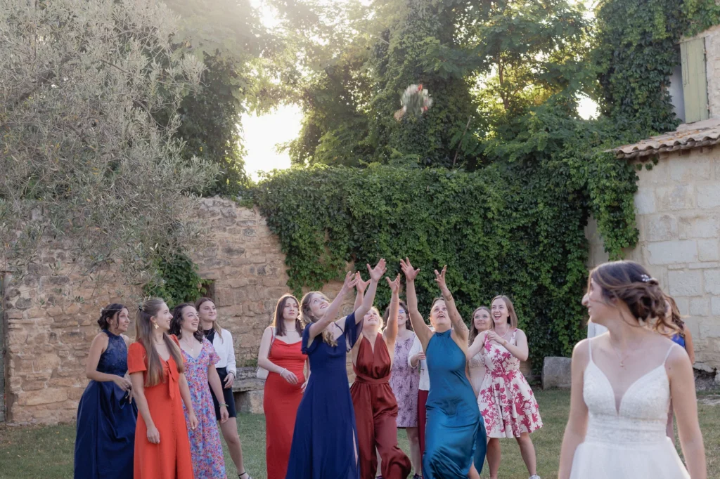 Mathilde lance son bouquet devant ses proches pendant le cocktail au Mas des Tourelles