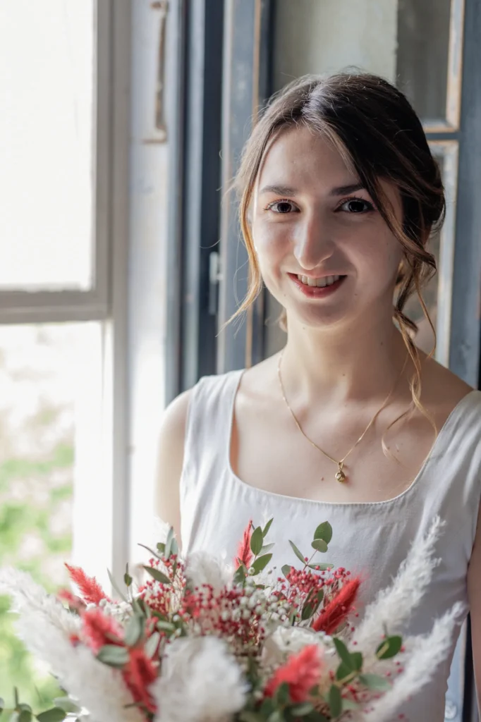 Portrait de Mathilde tenant son bouquet pendant les préparatifs de son mariage avec Romain