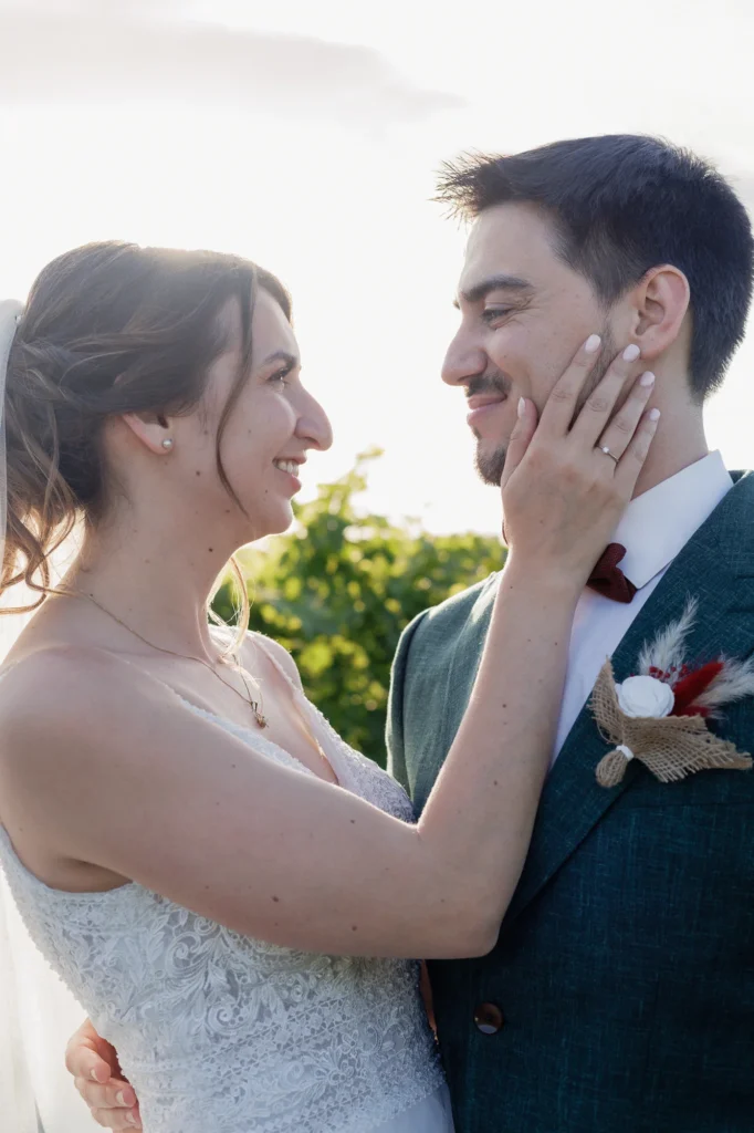 Mathilde pose sa main sur le visage de Romain pendant leur séance couple au Mas des Tourelles