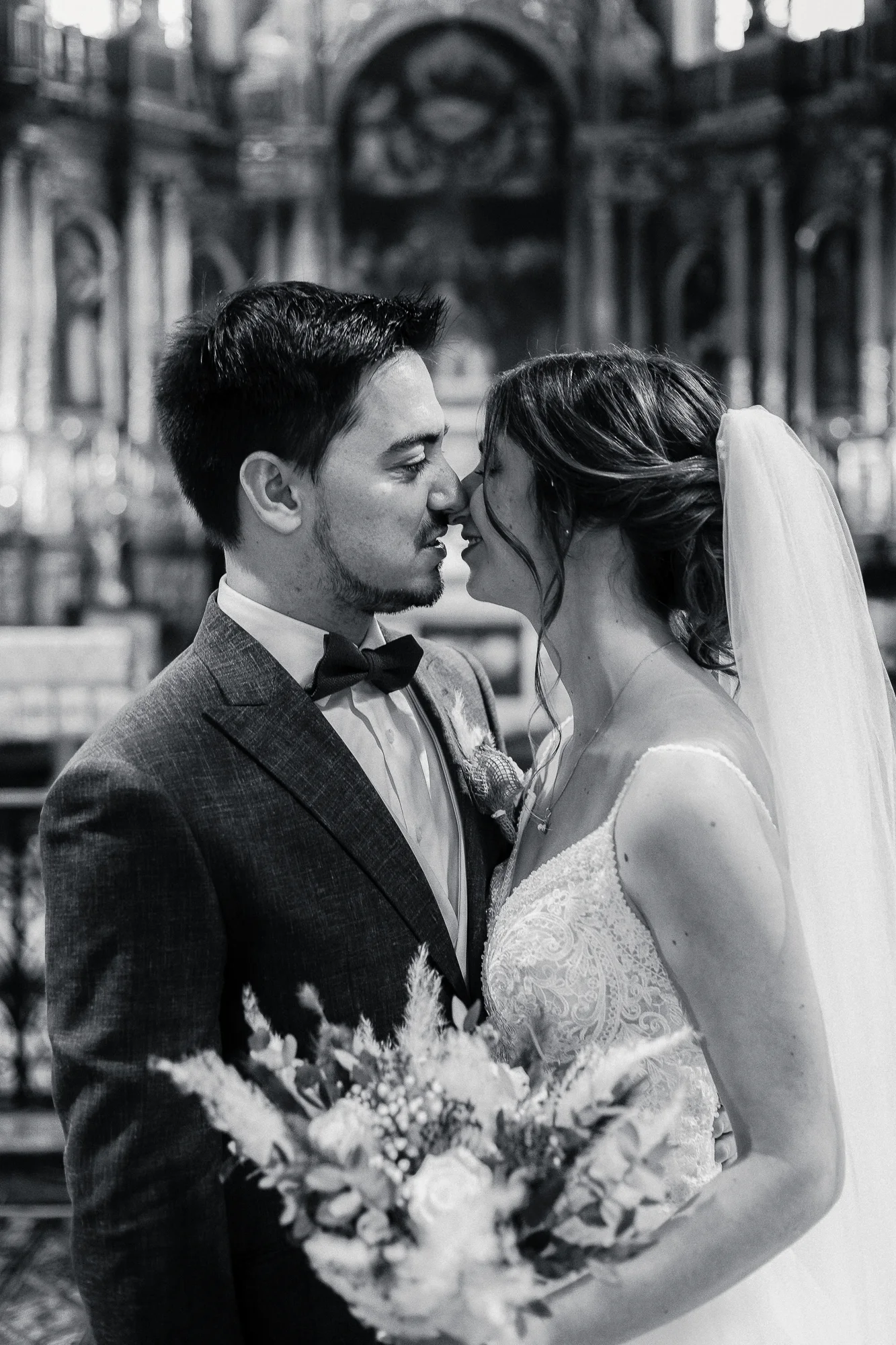 Portrait en noir et blanc de Mathilde et Romain, front contre front, dans la Basilique Saint-Pierre