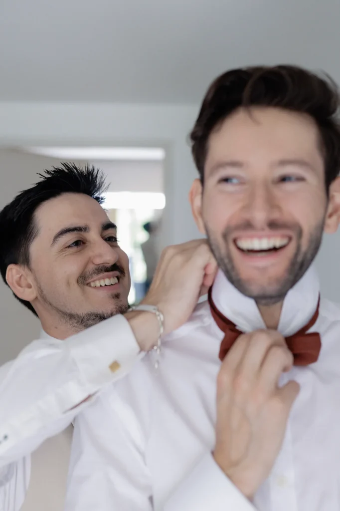 Romain ajuste le nœud papillon d'un proche pendant les préparatifs de son mariage